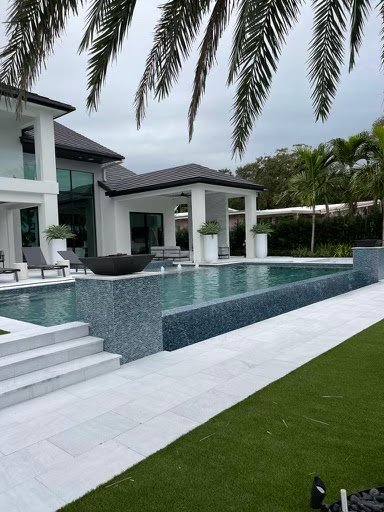 Modern home with a glass-tile raised spa wall, fire bowls and wide pool entry steps