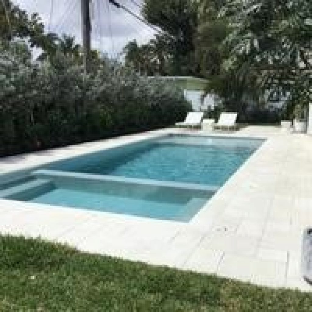 Rectangular pool with a sun shelf and white marble deck